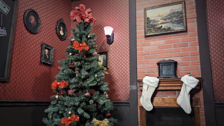 A Christmas tree and stockings by Sherlock's fireplace.